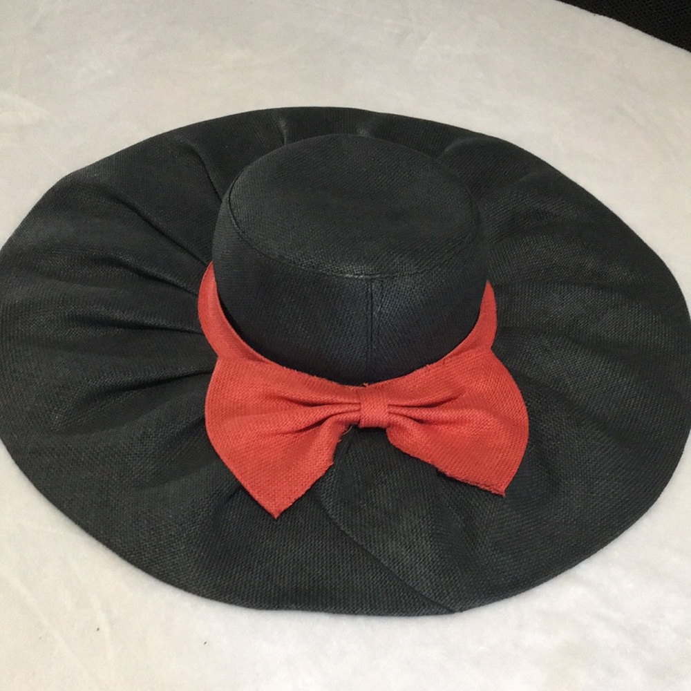 Woman’s black wide brim floppy burlap type hat with red bow.